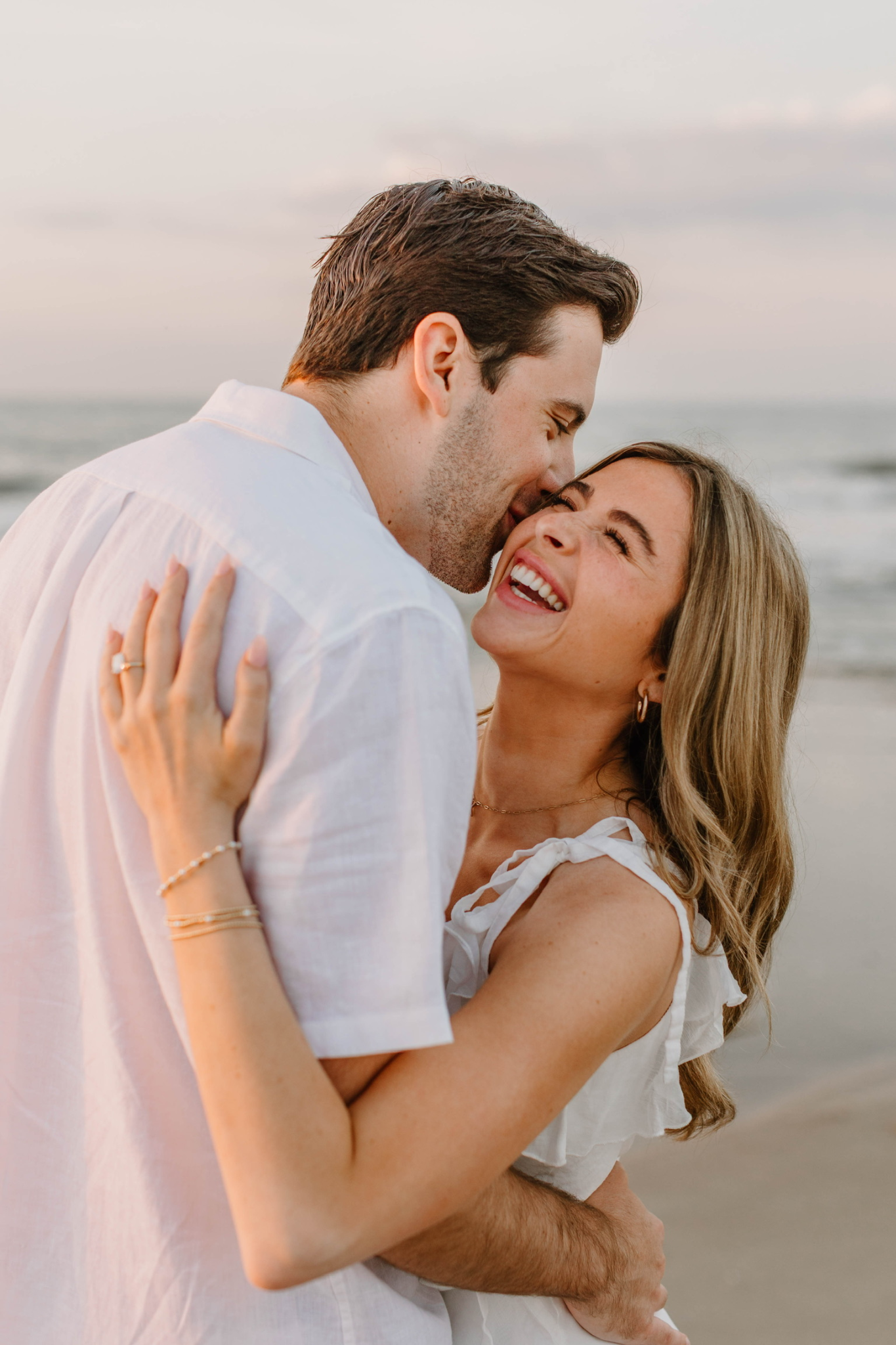 Kayleigh and Bryce laughing together on the beach